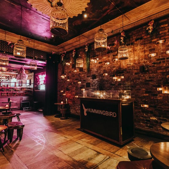 internal view of a restaurant with bird cage lamps hanging from the ceiling