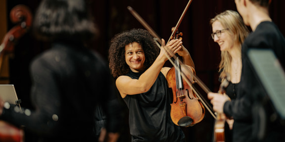 Smiling woman holds violin