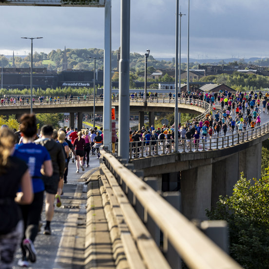 A viewpoint of the route over the Kingston Bridge with hundreds of runners on the road for the Great Scottish Run