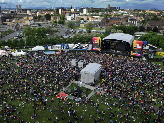 Aerial view of Glasgow Green, a crowd is gathered in front of a covered stage at Radio 1's Big Weekend.