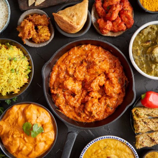 Variety of small plates of colourful Indian dishes