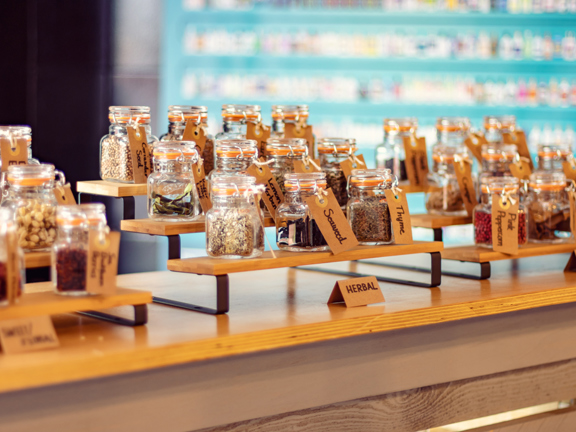 Mini bottles of herbs and spices with brown cardboard labels for making gin