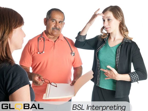 Three people standing in a group. One holds a file and wears a stethoscope around their neck. The other two are facing each other and one is signing. Along the bottom it reads Global Language Services BSL Interpreting.