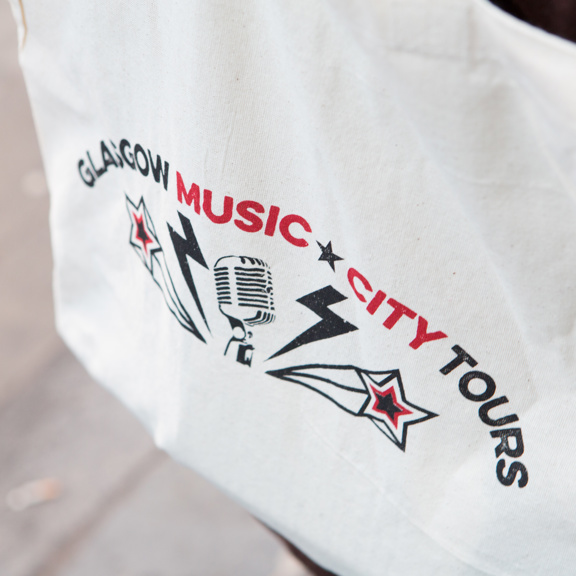 White tote bag with the words Glasgow Music City Tours and a stylised microphone