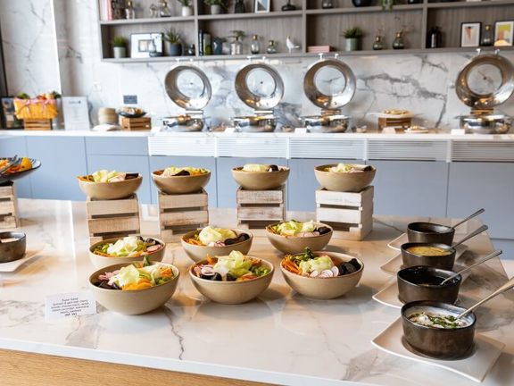 Marble topped table laid with bowls of food and dips.