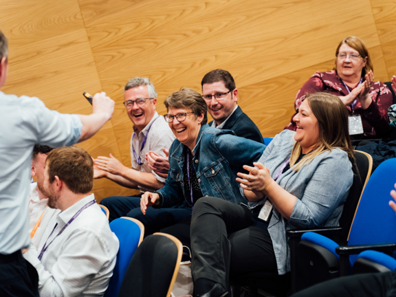 A group of people laughing and clapping