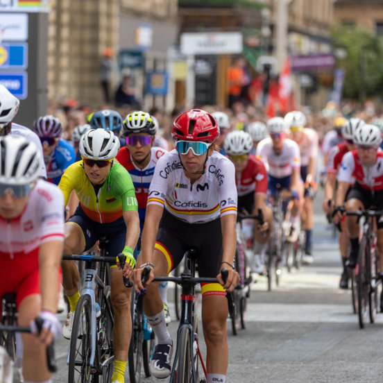 Group of professional cyclists riding through Glasgow city centre